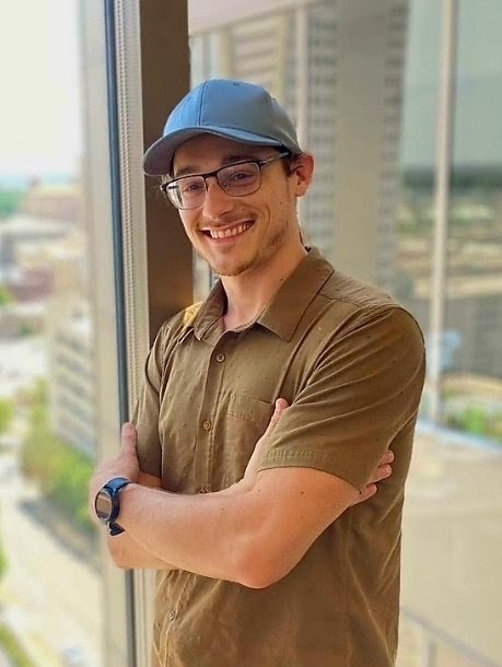 Michael Howell standing by a window overlooking downtown